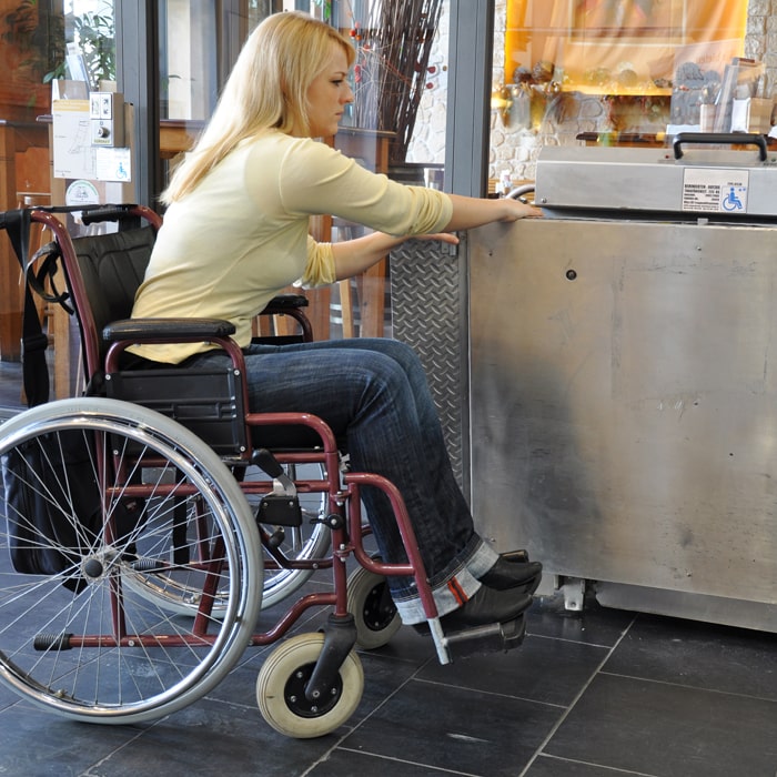 Frau im Rollstuhl vor defektem Lift
