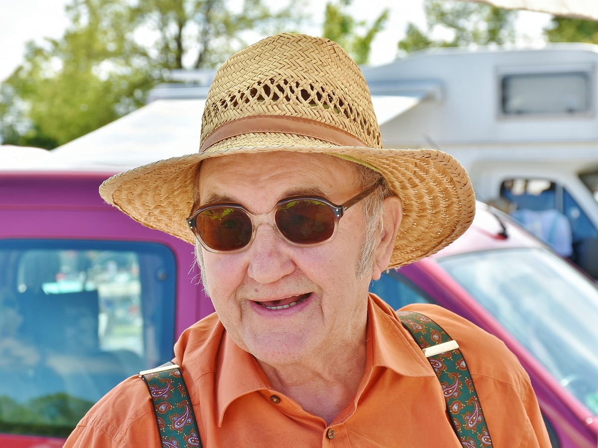 Fröhliche Seniorin mit Strohhut im Freien
