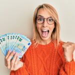 Glueckliche Frau mit 20 Euro Banknoten in Hand