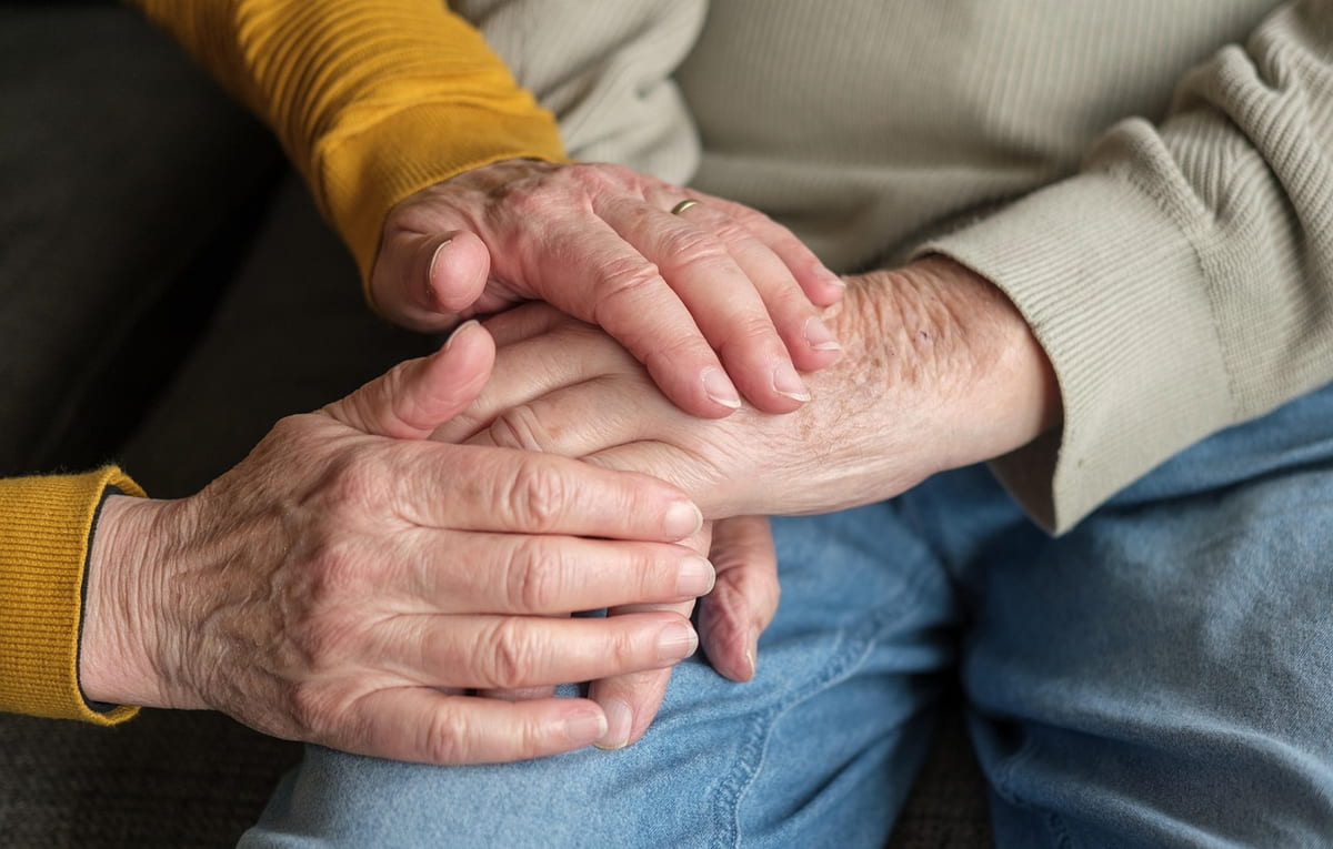 Junge Hand hält die Hand eines älteren Menschen