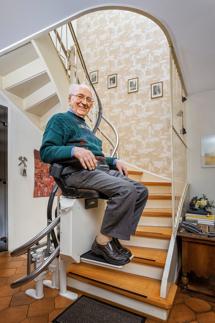 Mann benutzt den Treppenlift