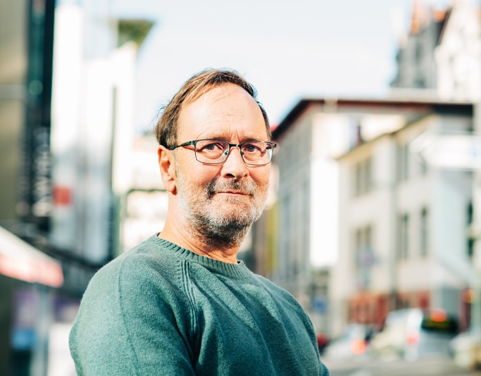 Person mit grünem Pullover und Brille