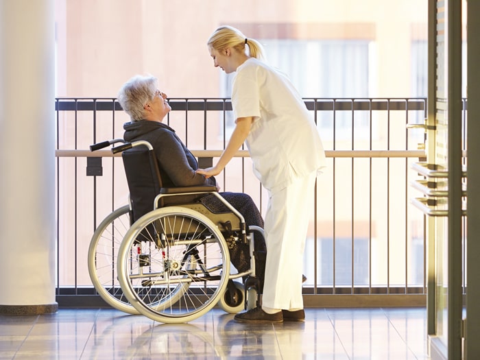 Rollstuhlpatient im Krankenhaus mit Krankenschwester