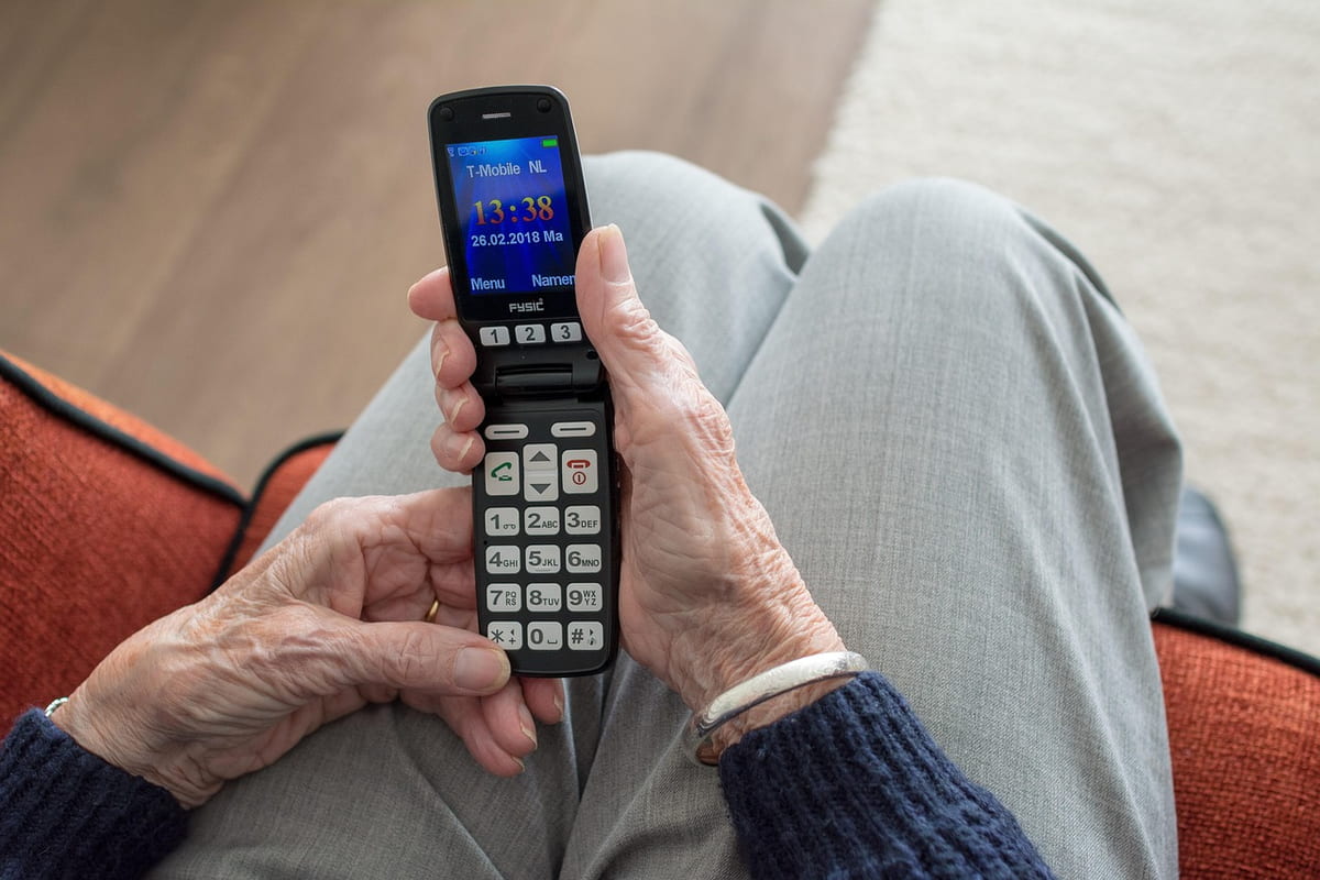 Seniorin bedient ein Seniorenhandy mit großen Tasten